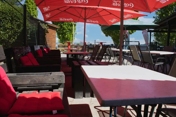 Tresen und rote Tische am Imbiss